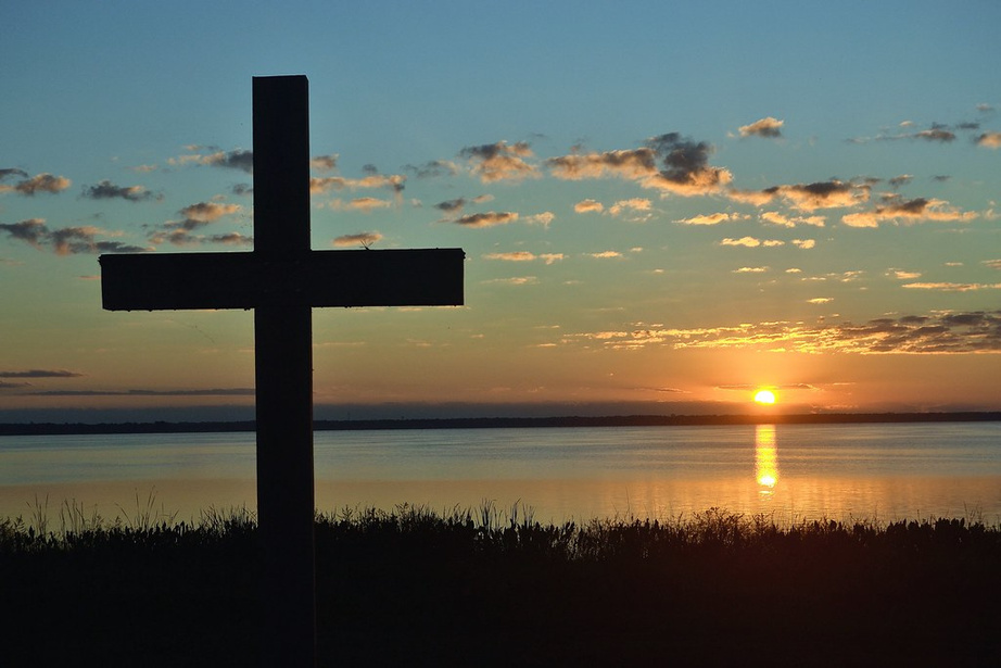 Sunrise with a cross in the foreground
